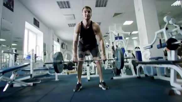 强壮的运动员在健身房用杠铃练习视频的预览图