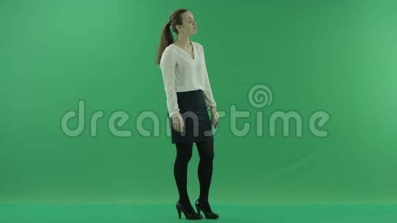 年轻的女商人正站在绿色的屏幕上自拍视频的预览图