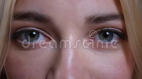 年轻漂亮的白种人白种人女性脸上的特写镜头蓝眼睛直视镜头视频的预览图