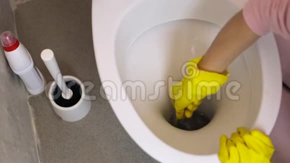 女人手戴着一只黄色手套用海绵清洗马桶视频的预览图