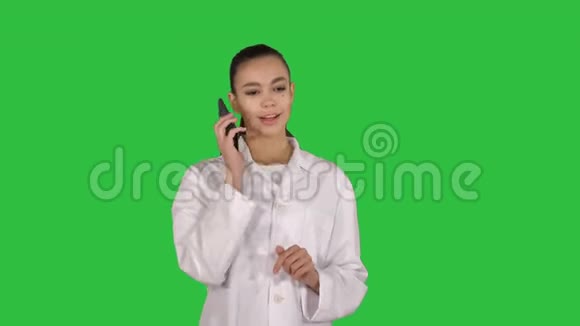 微笑的女医生在电话交谈而走在绿色屏幕Chroma键视频的预览图