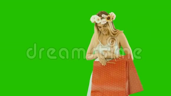 美丽的雀斑姑娘戴着花圈手里拿着礼物包新年包裹看着包裹视频的预览图
