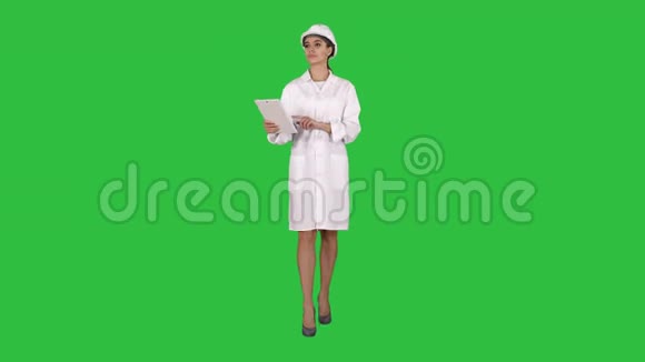 女工程师在绿色屏幕上检查她的平板电脑上的信息和物体Chroma键视频的预览图