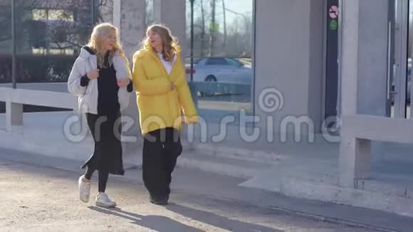 两个朋友正走在秋天的城市里幸运的是天气女孩们去聊天视频的预览图