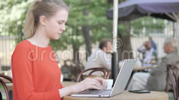 戴头巾的年轻女子坐在咖啡厅露台上视频的预览图
