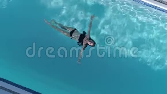 美丽身材的女性在暑假在蓝色游泳池里穿着泳衣放松身心视频的预览图