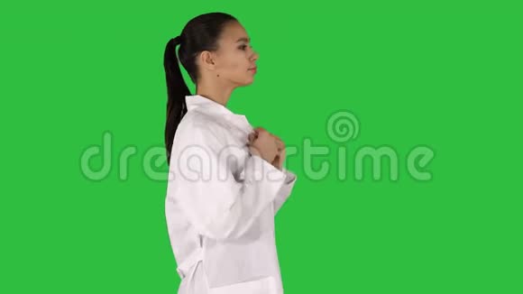 年轻的女药剂师穿着白色长袍统一走在绿色屏幕上Chroma键视频的预览图