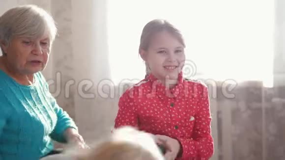 祖母梳孙女头发另一个女孩在玩操纵杆游戏视频的预览图