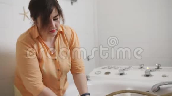 水电水疗治疗师做按摩给一个男人洗澡室内穿黄色西装的女人手里拿着软管视频的预览图