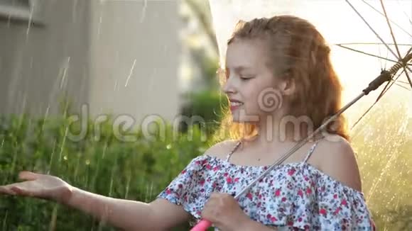 小女孩在雨中打伞可爱的孩子有有趣的户外活动视频的预览图