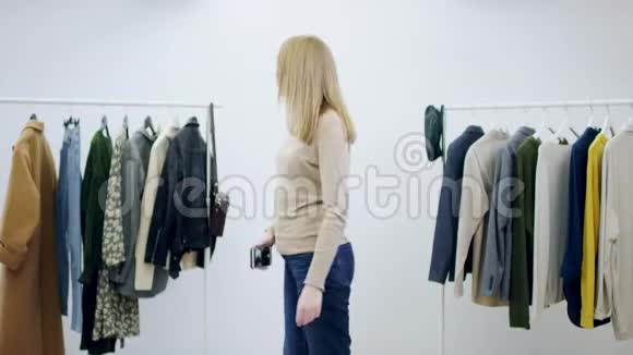 年轻漂亮的女人正在试衣间用一件连衣裙自拍视频的预览图