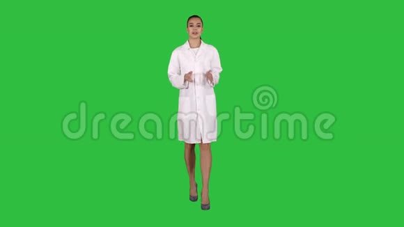 女医生在绿色屏幕上行走时向摄像机解释和交谈Chroma键视频的预览图