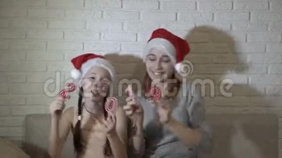孩子们戴着圣诞老人的帽子举着数字2019坐在沙发上跳舞微笑新的象征视频的预览图
