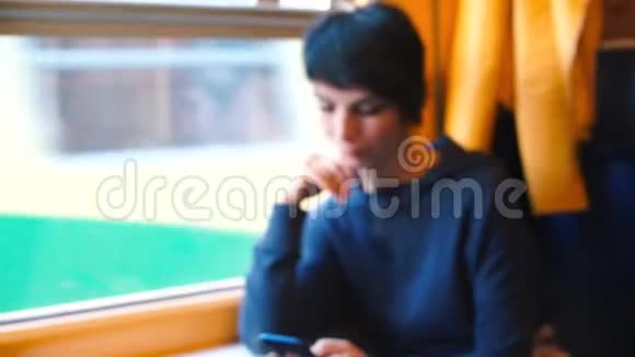 女人在火车上用智能手机视频的预览图