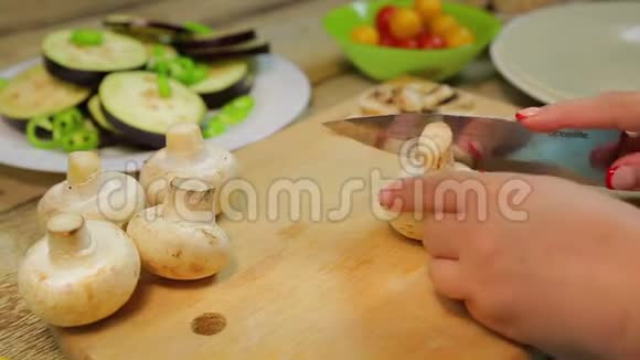 一个女人用一把刀在木板上把香瓜蘑菇切成薄片时间跨度视频的预览图