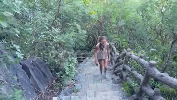 女孩上了满是丛林的山上的老楼梯视频的预览图