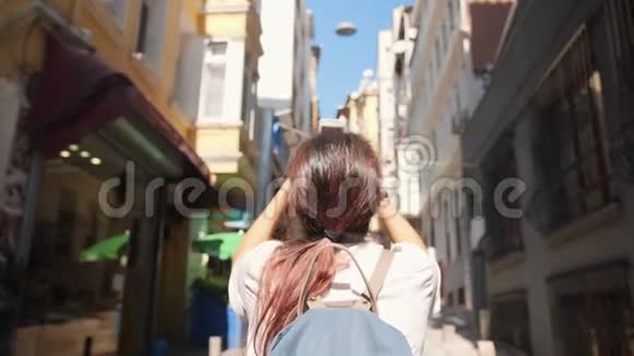 年轻的旅游妇女用手机拍摄伊斯坦布尔街道的照片土耳其4K慢动作视频的预览图