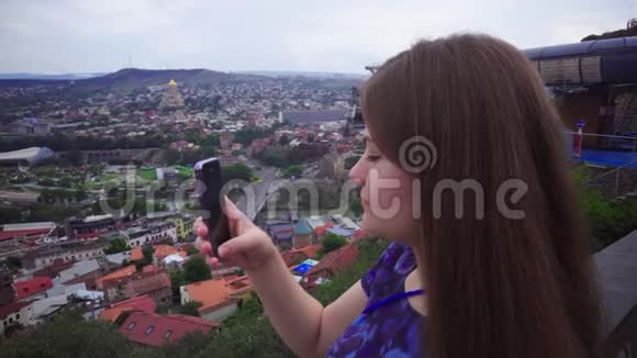 女孩年轻美丽的游客正在智能手机摄像头上拍照微笑着展望未来视频的预览图