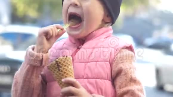 快乐和快乐的女婴吃巧克力冰淇淋与华夫饼锥美味的甜点4k视频的预览图