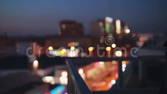 梯田上的女人向前看享受夜晚城市的平静视频的预览图