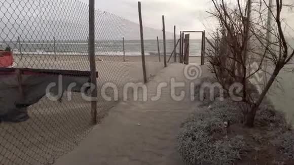 日落时分在风中漫步走在一条有栅栏和沙质的小路上走向大海视频的预览图