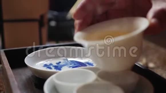 茶师将绿茶倒入茶杯中用于盖湾或钟中国传统功夫或功夫茶道视频的预览图