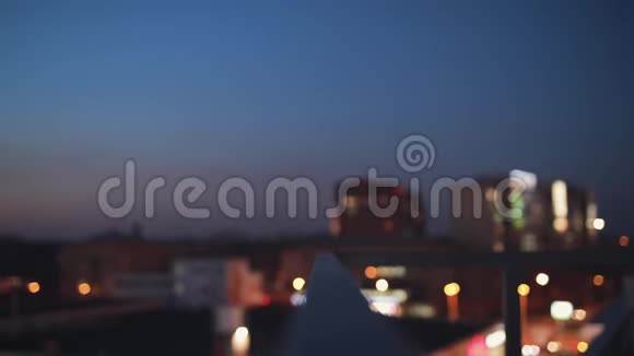 梯田上的女人向前看享受夜晚城市的平静视频的预览图