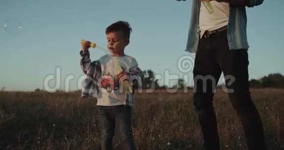 跑步的甜美男孩日落时分穿过田野魅力四射的三岁男孩视频的预览图