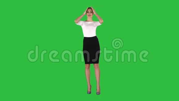 穿裙子的女孩打扮和检查她的外表就像她看着镜子上的绿色屏幕Chroma键视频的预览图