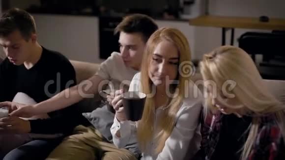 现代青少年坐在客厅里喝酒看电视温馨的家庭聚会视频的预览图