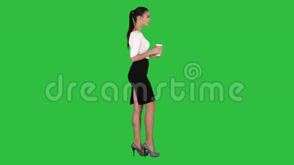 放松的时尚女商人喝咖啡走在绿色屏幕Chroma键视频的预览图
