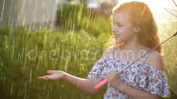 小女孩在雨中打伞可爱的孩子有有趣的户外活动视频的预览图