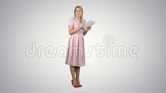穿着粉色衣服的女青年女士站在平板电脑上在渐变背景下给相机演讲视频的预览图