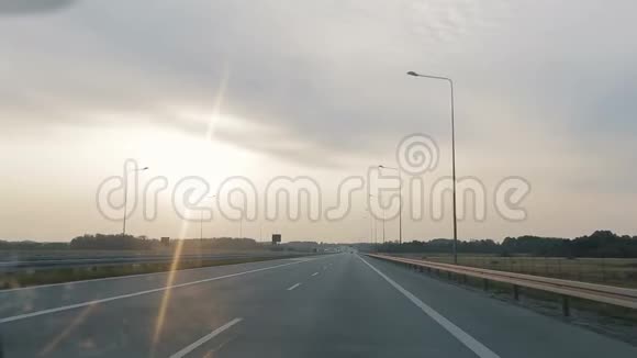 清晨日出时POV沿着宽阔的空旷的早晨道路行驶视频的预览图