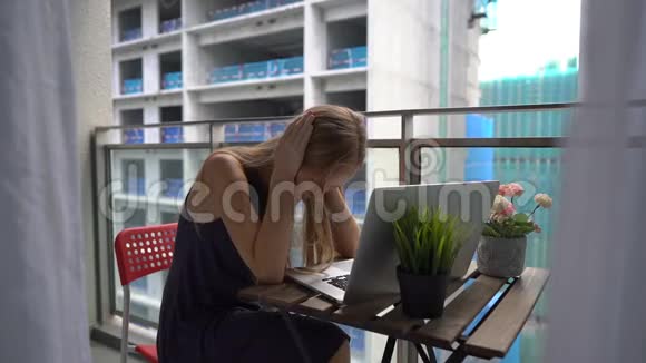 一名年轻女子坐在阳台上拿着笔记本被一个人发出的一声巨响击中视频的预览图
