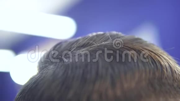 理发师的特写镜头在客户头发上缓慢地泼水视频的预览图