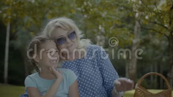 微笑着奶奶和公园里的可爱女孩说话视频的预览图