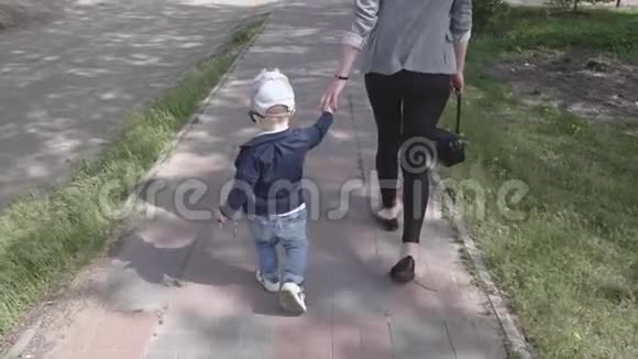 母亲和她的小儿子牵着手走着母亲和童年的概念视频的预览图