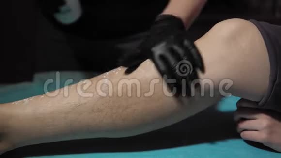 美容师对女性腿部使用特殊的白色滑石粉视频的预览图