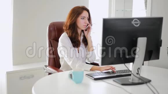 漂亮的女商人在办公室里打电话视频的预览图