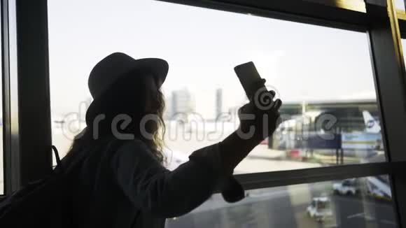 女人在机场窗口附近自拍视频的预览图