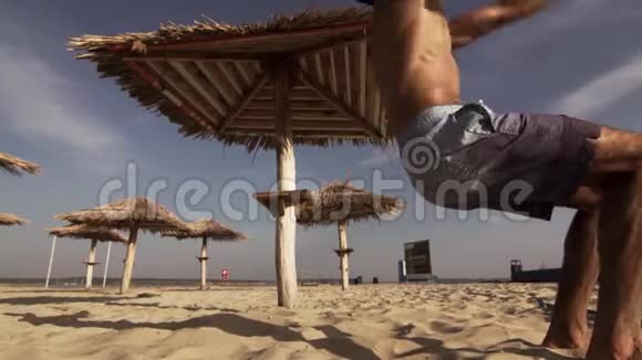 沙滩上跳跃的年轻男运动员视频的预览图