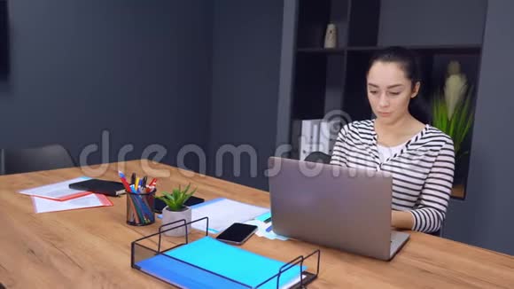 自信的女商人在她的现代办公室里用笔记本电脑工作视频的预览图
