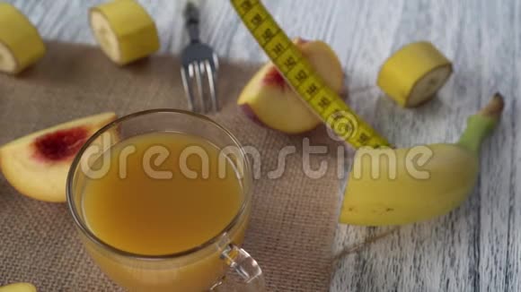 桃子杯子里的果汁麻布上的叉子和一张有厘米的木桌视频的预览图