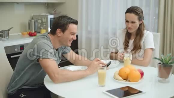 快乐的一对夫妇一起在厨房吃早餐视频的预览图