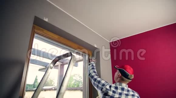 家庭改善手巧的人把油漆胶带贴在窗户上视频的预览图