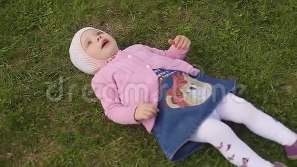 一个夏天戴着帽子的两岁小女孩坐在绿草上视频的预览图