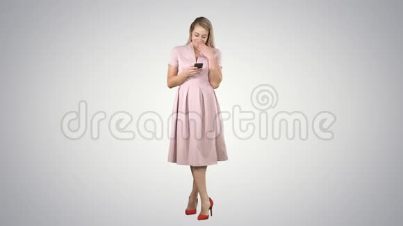 一个穿着夏季服装的漂亮微笑女孩使用手机的肖像在渐变背景上发短信视频的预览图