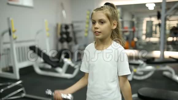 健身房里戴哑铃的女孩视频的预览图