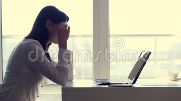 工作过度精疲力竭疲惫不堪的年轻女商人摘下眼镜休息着睡在办公桌上的笔记本电脑上视频的预览图